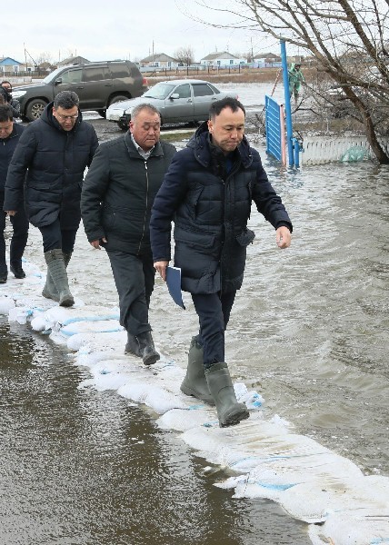 Архимед МУХАМБЕТОВ (справа) шагает по мешочкам с песочком.
