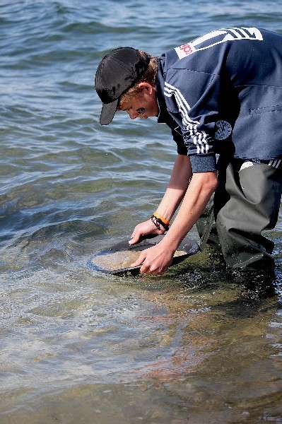 Юные геологи работают с промывочным лотком.