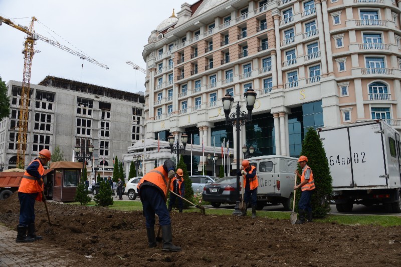 Рабочие демонтируют забор вокруг одного из отелей в центре Алматы.