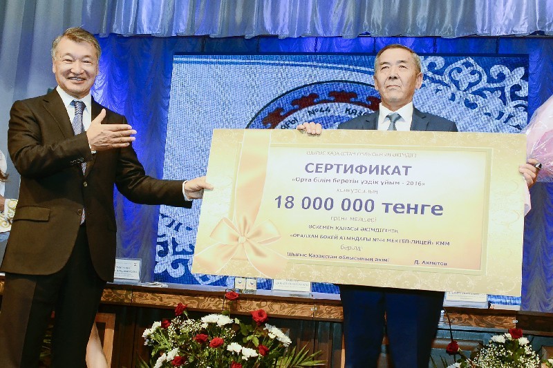 Даниал АХМЕТОВ вручает чек директору школы-лицея № 44 Танаткану ТУМЕНБАЕВУ.